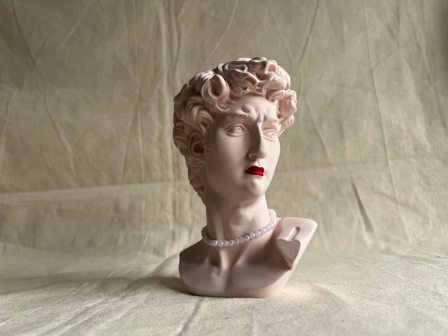 David's bust with red lipstick and pearls