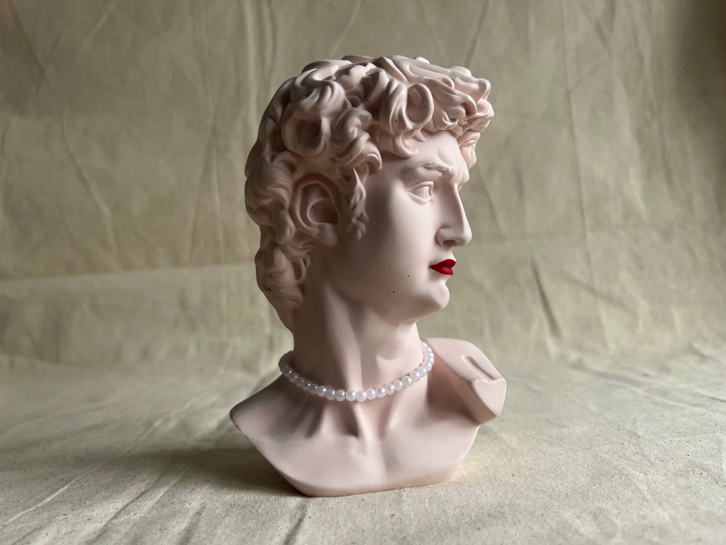 David's bust with red lipstick and pearls