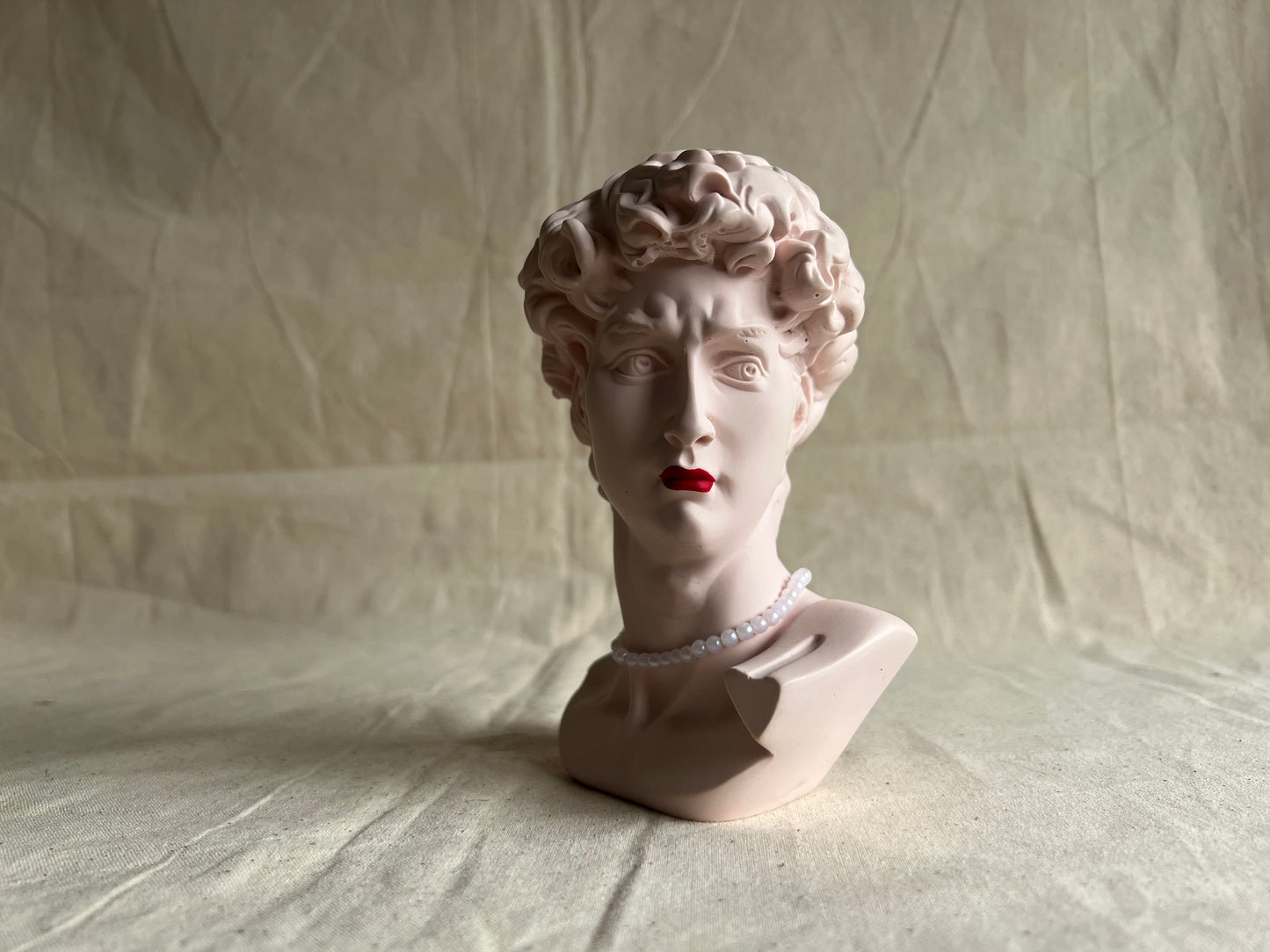 David's bust with red lipstick and pearls